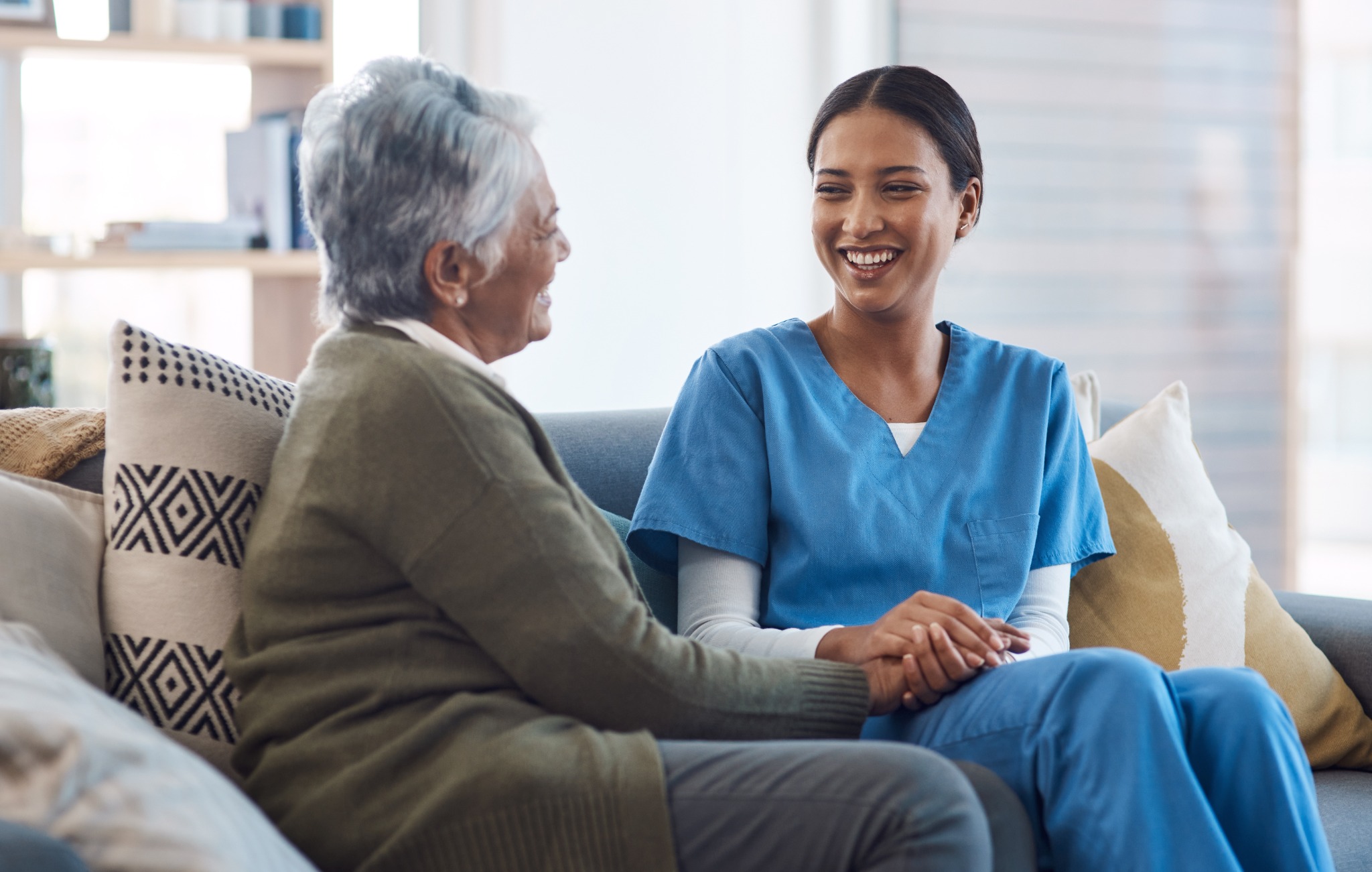 Support professional having a warm conversation with an older adult at home